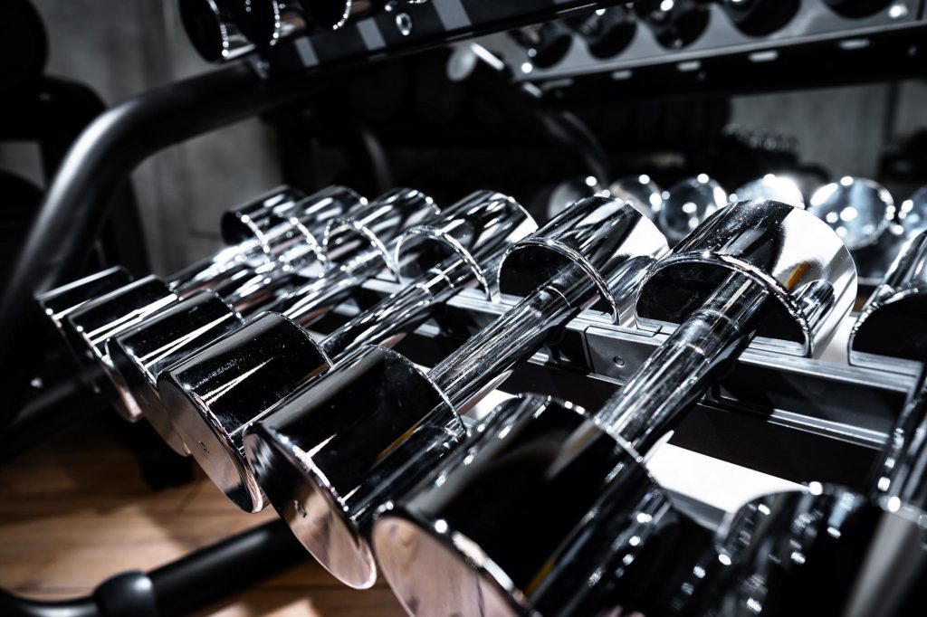 rows of metal dumbbells on rack for bodybuilding